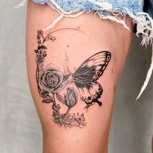 Illustrative upper leg tattoo featuring a stunning combination of bird, butterfly, and flower motifs. Located in Los Angeles, US.