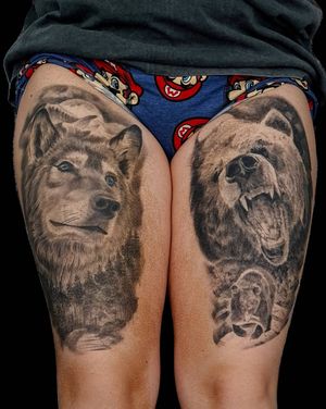 Stunning realism tattoo of a fierce bear and wolf by artist Mauro Imperatori, perfect for the upper leg.