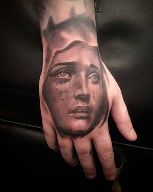 Experience the raw emotion of a woman shedding tears in this stunning black and gray hand tattoo by Mauro Imperatori.