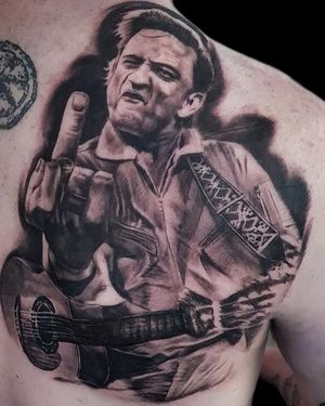 Get mesmerized by Mauro Imperatori's black and gray realism masterpiece of Johnny Cash's iconic guitar on your upper back.