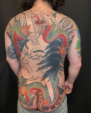 Immerse yourself in the stunning Japanese artistry of Daniel Werder with this back piece featuring a snake, sakura, sword, namakubi, and cherry blossom motif.