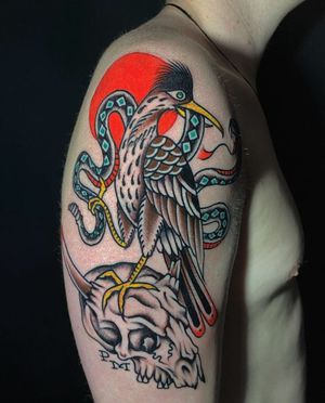 Traditional style upper arm tattoo featuring a skull and heron motif, perfect for those in Los Angeles.