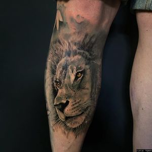 Impressive black and gray lion tattoo by tattoo artist Marie Terry, bringing the king of the jungle to life on your lower leg.