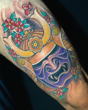 Beautifully crafted tattoo featuring sakura, cherry blossom, helmet, and mask motifs by renowned artist Daniel Werder.
