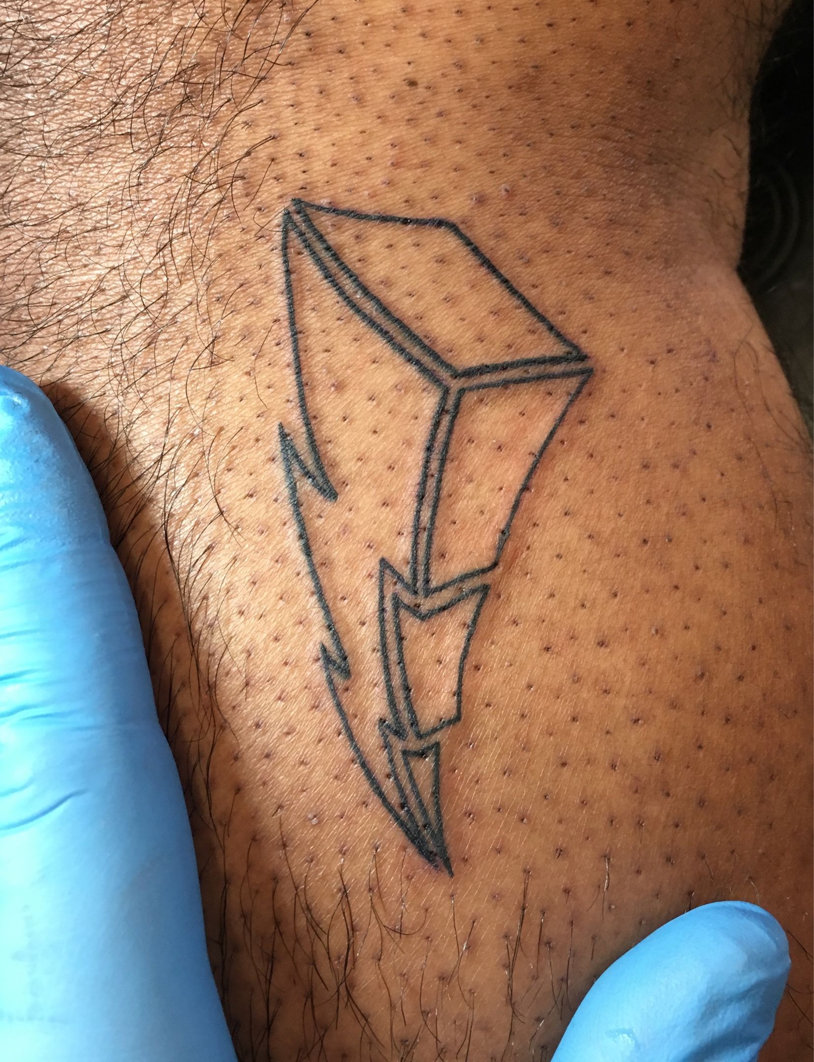 Minimalist lightning bolt tattoo in white ink (healed).