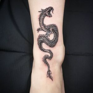 Get an intricate and powerful Japanese dragon tattoo on your foot by tattoo artist Fernando Joergensen. Embrace strength and tradition in one design.