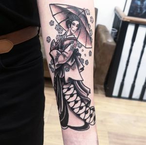 Experience the elegance and mystery of a Japanese geisha holding an umbrella, expertly inked in black and gray by Fernando Joergensen.