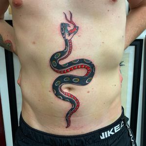 Illustrative snake design by Andrea Furci, a timeless and bold choice for your stomach tattoo.