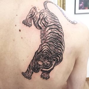 Capture the strength and beauty of a tiger in this stunning black and gray tattoo by Fernando Joergensen.
