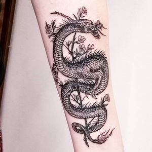 Experience the power and beauty of a black and gray dragon tattoo expertly inked by Fernando Joergensen on your forearm.