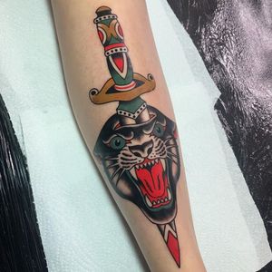 Impressive shin tattoo by Andrea Furci featuring a fierce panther and dagger in traditional style.