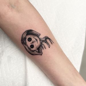 Unique blackwork forearm tattoo inspired by Coraline, created by the talented artist Miss Vampira.