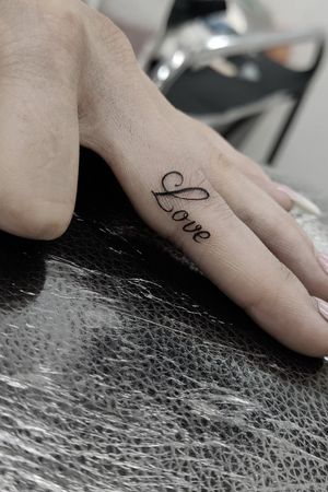 Get a chic and subtle small lettering tattoo by the talented artist Mary Shalla, perfect for your finger placement.