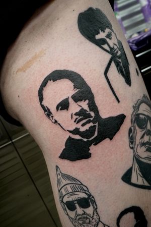 Masterfully detailed blackwork tattoo of Marlon Brando and Robert De Niro by the talented artist Miss Vampira.