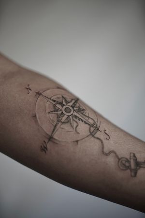 Close shot of a compass with anchor tattoo done by Brandon (@rvckage)