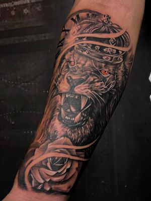 roaring lion tattoo custom with rose and crown done on arm