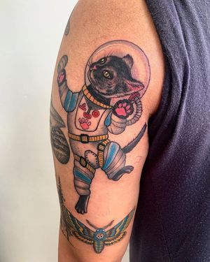Experience the playful adventure with this new-school illustrative tattoo of an astronaut cat on your upper arm by Brigid Burke.