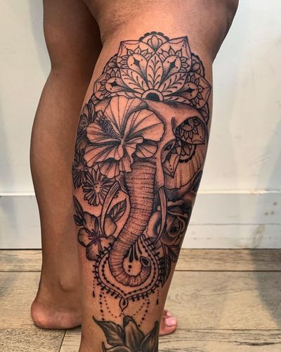 Unique illustrative tattoo by Brigid Burke on lower leg featuring an elephant, flower, and mandala design.