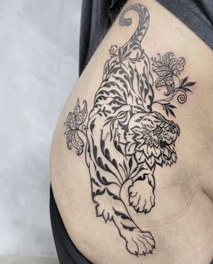 Get a stunning blackwork, ornamental tattoo featuring a fierce tiger and delicate flower on your upper leg in Los Angeles, US.