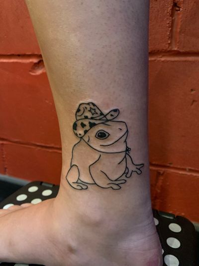 Get a whimsical frog in top hat tattoo on your lower leg in London. Fine line and illustrative style.