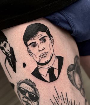 Get a sleek blackwork tattoo of a cigarette and iconic Tommy Shelby portrait on your upper leg by Miss Vampira!