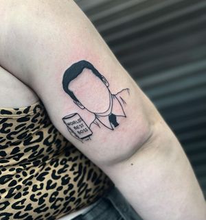 Illustrative blackwork tattoo of Steve Carell's face on a mug, by Miss Vampira. Placement on upper arm.