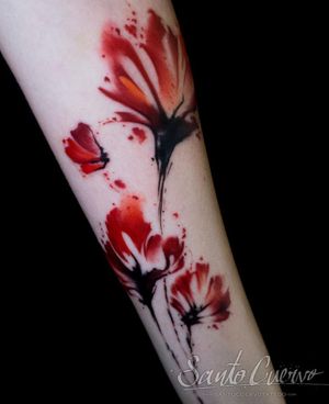 Elegant forearm tattoo featuring a beautifully detailed watercolor flower design by the talented artist Alex Santo.