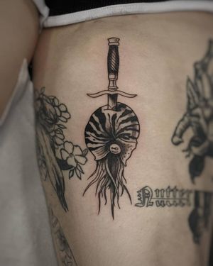 Elegant black and gray fine line tattoo featuring a dagger, shrimp, and shell by Luca Salzano.