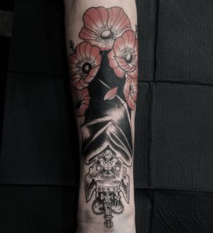 Elegant forearm tattoo by Luca Salzano in black and gray, featuring a bat, flower, and crown in fine line blackwork.