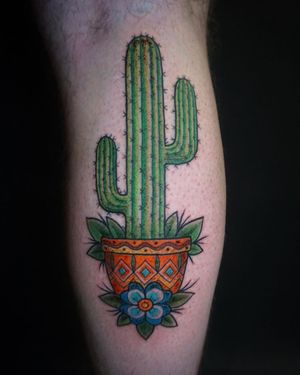 A stunning illustrative tattoo of a cactus in a vase, beautifully designed by tattoo artist Aygul. Perfect for the lower leg placement.
