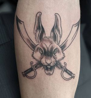 Captivating black and gray forearm tattoo by Luca Salzano, featuring a graceful rabbit and a powerful sword motif.