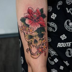 Experience the vibrant new school style with this stunning peony and skull tattoo on your upper arm by artist Luca Salzano.