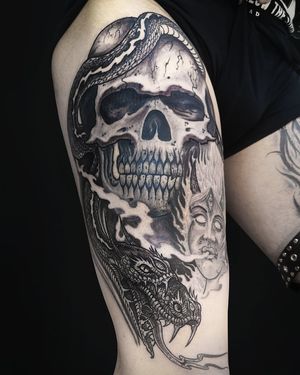Exquisite black and gray design by Fernando Joergensen featuring a snake intertwined with a skull on the upper leg.
