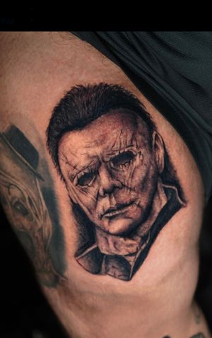 Blackwork illustrative tattoo on upper leg by Miss Vampira, featuring iconic mask of Michael Myers.