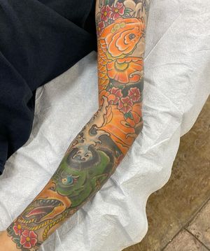 Experience the beauty and grace of a traditional Japanese koi fish tattoo, expertly crafted by renowned artist Daniel Werder on your sleeve.