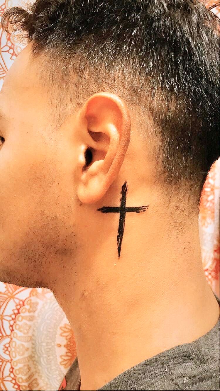 Tiny Christian cross tattoo on the neck