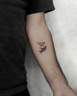 Get a sleek blackwork airplane tattoo on your forearm, inspired by the iconic Los Angeles skyline. Perfect for aviation enthusiasts!