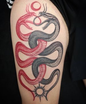Traditional black and gray snake tattoo on upper arm in London, combining classic style with modern flair.