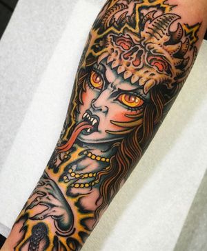 Express your edgy side with a unique forearm tattoo featuring a skull, necklace, and kali motif. Located in London, GB.