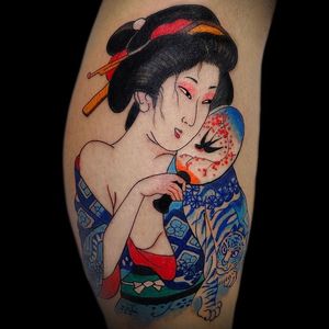 Immerse yourself in Japanese culture with this stunning lower leg tattoo featuring a graceful geisha, fierce tiger, elegant fan, and majestic bird. Perfectly executed in London, GB.