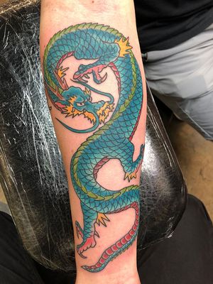 Immerse yourself in the mythical world of Japanese culture with this fierce dragon forearm tattoo expertly inked by Shawn Nutting.