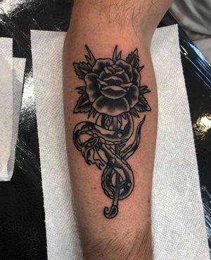 Get a stunning blackwork snake and flower tattoo on your forearm in Los Angeles, combining elements of beauty and symbolism.