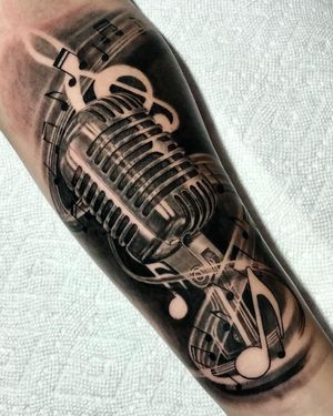 Get a stunning blackwork illustrative tattoo of a microphone on your forearm in Los Angeles. Achieve a lifelike design that captures your passion for music.