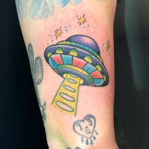 Unique spaceship design tattooed on arm by artist Shawn Nutting, showcasing illustrative style.