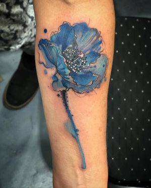 Beautifully vibrant watercolor flower tattoo on forearm by Aygul.