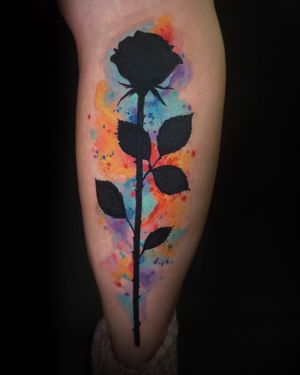 Get a stunning flower tattoo by Aygul, combining blackwork and watercolor styles on your lower leg.