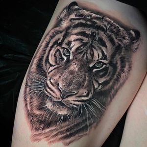 Get a fierce and realistic blackwork tiger tattoo on your upper leg in London, GB. Stand out with this powerful design!