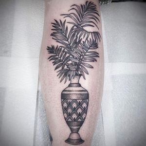 Elegant black and gray dotwork tattoo of a beautiful flower in a vase, perfect for the lower leg in London.