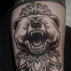 Intricate dotwork design featuring a fierce bear with fangs on upper leg by Luca Salzano.