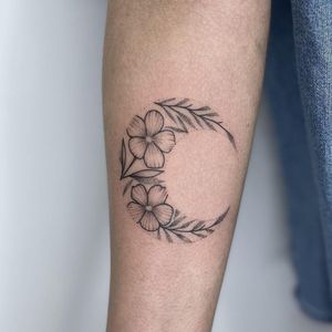 Elegant dotwork and fine line design featuring a moon and flower motif on the forearm in London.